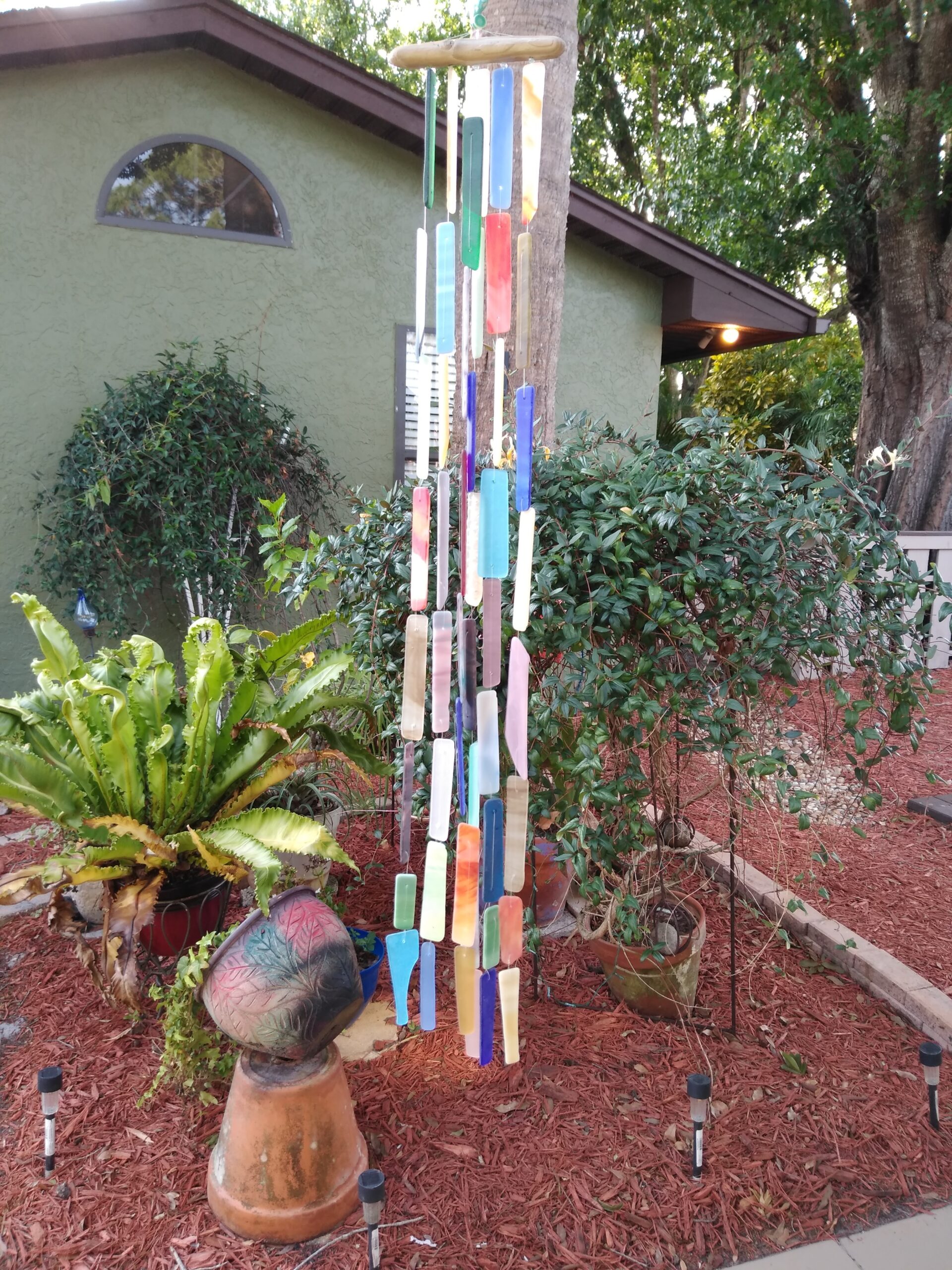 A handmade windchime made of stained glass.