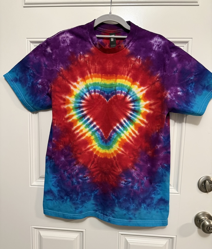 Tie-dyed t-shirt hanging on a door.