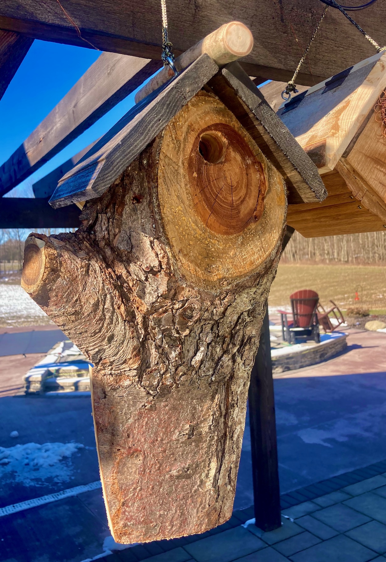 A handmade birdhouse made from a tree trunk.