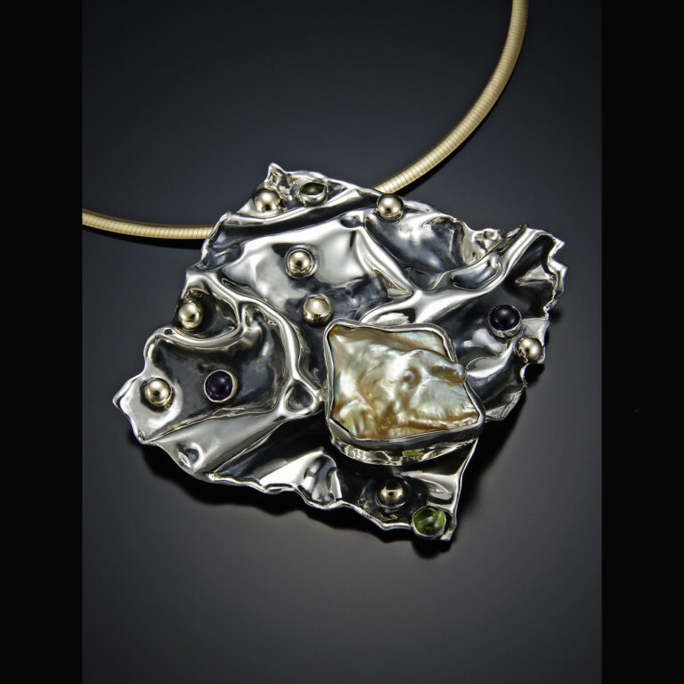 A hand-fabricated silver piece of jewelry.