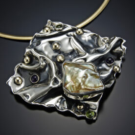 A hand-fabricated silver piece of jewelry.