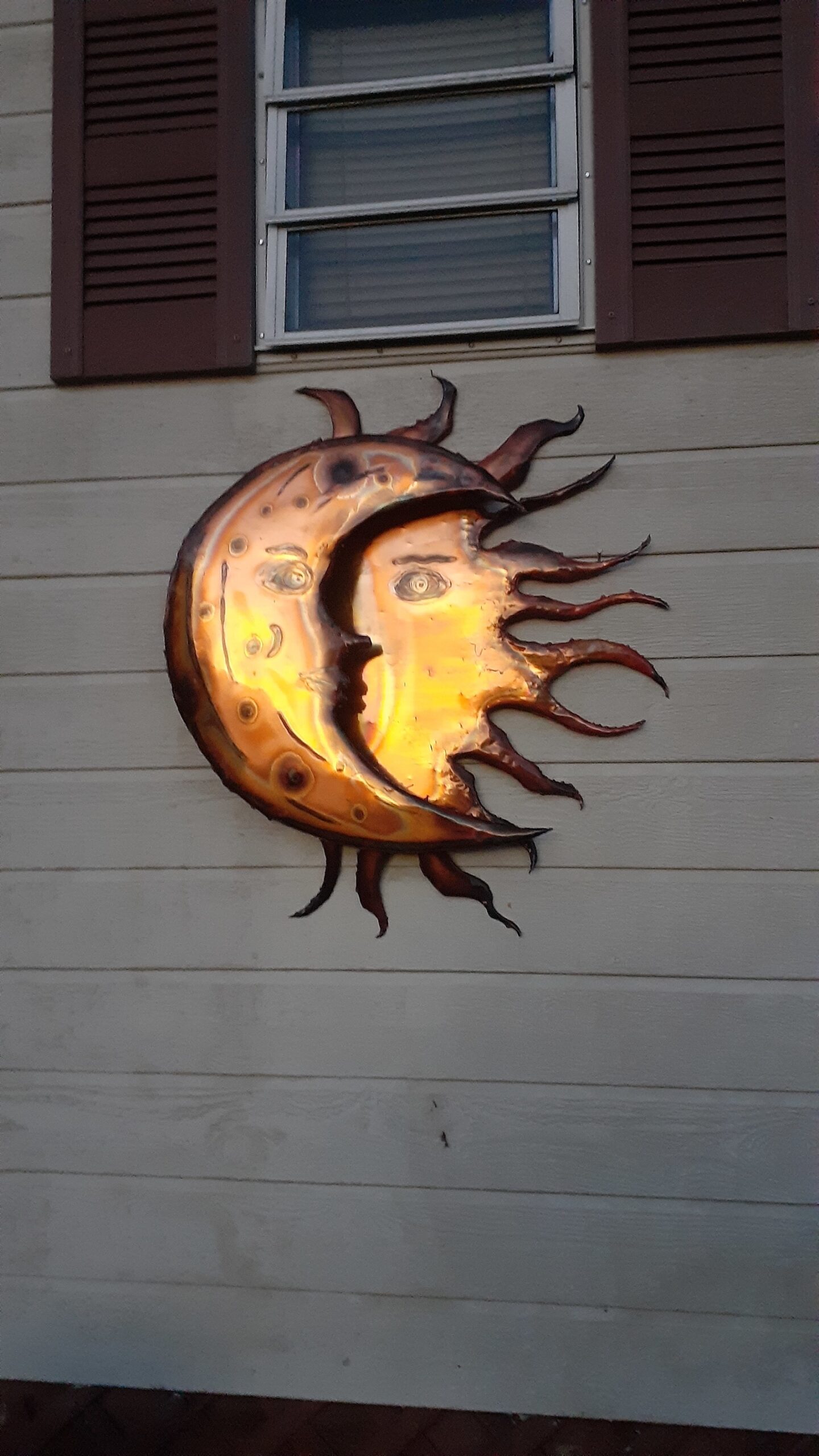 A hand-melted metal sculpture of a sun and moon.