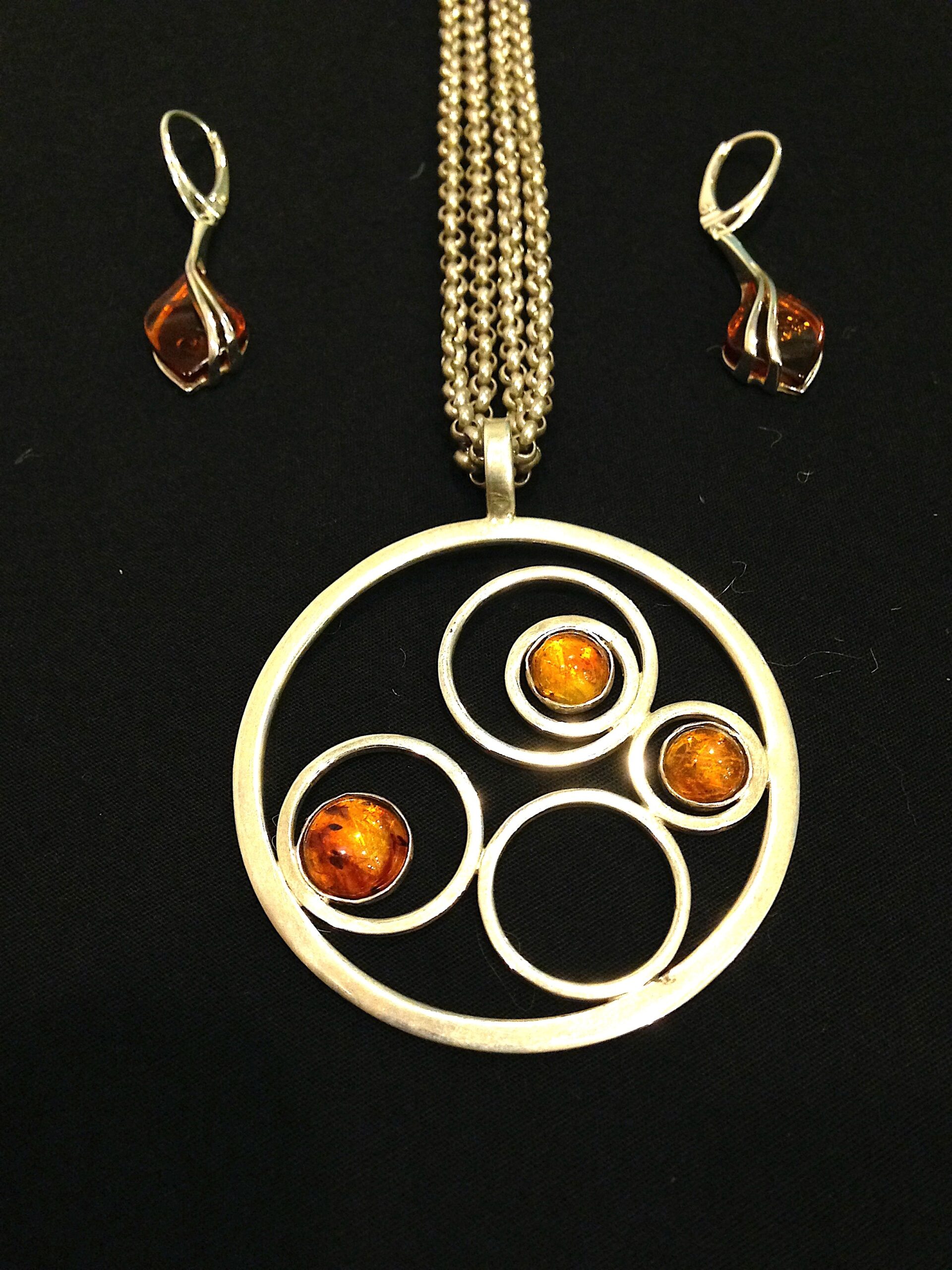 A handmade necklace made of gold metal and amber.